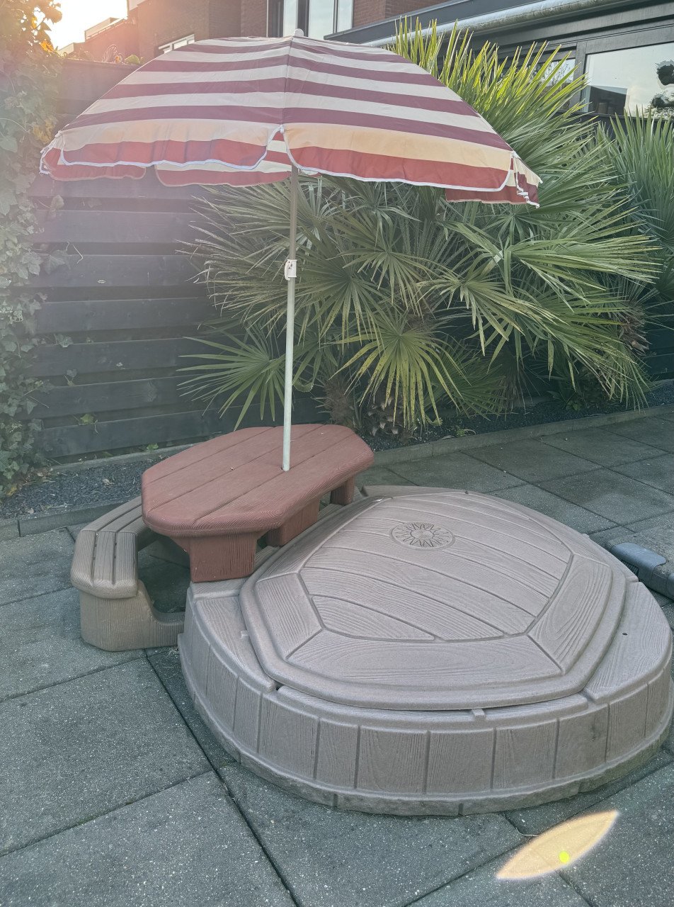 Zandbak met bankje en parasol